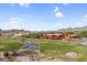 Picturesque aerial view of a golf course near the clubhouse and residential homes surrounded by mountains at 6145 E Snowdon St, Mesa, AZ 85215