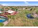 Aerial view of a lush golf course with a clubhouse, pond and fountain surrounded by houses in the community at 6145 E Snowdon St, Mesa, AZ 85215