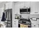 This kitchen features stainless steel appliances, white cabinets and subway tile backsplash at 6145 E Snowdon St, Mesa, AZ 85215