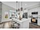 Well-lit kitchen with island seating, modern pendant lights, and stainless steel appliances at 6145 E Snowdon St, Mesa, AZ 85215