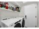 Practical laundry room with a front load washer/dryer and ample shelving at 6145 E Snowdon St, Mesa, AZ 85215