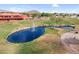 Aerial view of a scenic pond with fountain surrounded by a golf course and landscaping within the community at 6145 E Snowdon St, Mesa, AZ 85215