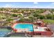Aerial shot showcasing a sparkling community pool with lounge chairs, set amongst lush landscaping and tennis courts at 6145 E Snowdon St, Mesa, AZ 85215