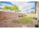 Backyard showcasing lush lawn, mature trees, and a water fountain, all enclosed by a block fence at 636 E Redondo Dr, Gilbert, AZ 85296
