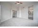 Spacious bedroom with neutral walls, carpet flooring, ceiling fan, and access to the bathroom at 636 E Redondo Dr, Gilbert, AZ 85296