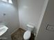 A functional half bath featuring a white toilet, vanity and sink, and a simple towel rack at 6842 S 42Nd Pl, Phoenix, AZ 85042
