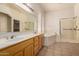 Bathroom features a large mirror, dual sinks, a soaking tub, and a glass-enclosed shower at 710 W Cherrywood Dr, Chandler, AZ 85248
