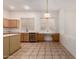 Bright kitchen featuring tile flooring, wood cabinets, an island, and stainless steel dishwasher at 710 W Cherrywood Dr, Chandler, AZ 85248