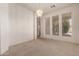 Well-lit living room with carpet, chandelier, and large windows overlooking the lush outdoor landscape at 710 W Cherrywood Dr, Chandler, AZ 85248