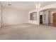 Spacious carpeted living room with archways, neutral tones, and elegant chandelier lighting at 710 W Cherrywood Dr, Chandler, AZ 85248