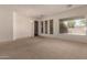 Bright living room with carpet, arched entryways and large windows offering an abundance of natural light at 710 W Cherrywood Dr, Chandler, AZ 85248