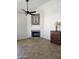 Cozy living room with a fireplace, ceiling fan, and accent furniture on a tiled floor at 7724 W Topeka W Dr, Glendale, AZ 85308