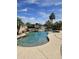 Beautiful backyard pool with rock waterfall feature and lush tropical landscaping overlooking a lake at 7724 W Topeka W Dr, Glendale, AZ 85308