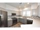 A clean kitchen featuring stainless steel appliances, gray lower cabinets, white countertops, and hard wood floors at 8180 E Shea Blvd # 1075, Scottsdale, AZ 85260