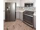 A kitchen featuring stainless steel appliances, gray lower cabinets, white upper cabinets, and hard wood floors at 8180 E Shea Blvd # 1075, Scottsdale, AZ 85260