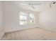 Bright bedroom featuring a ceiling fan, two windows, and neutral carpet at 8328 E Chaparral Rd, Scottsdale, AZ 85250