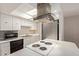Bright kitchen features white cabinets, stainless steel appliances, cooktop island and a skylight at 8328 E Chaparral Rd, Scottsdale, AZ 85250