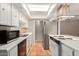 Efficient kitchen with stainless steel appliances, white cabinets, and terracotta tile flooring at 8328 E Chaparral Rd, Scottsdale, AZ 85250