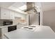 Bright kitchen features white cabinets, stainless steel appliances, cooktop island and a skylight at 8328 E Chaparral Rd, Scottsdale, AZ 85250