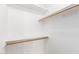Walk-in closet with wooden rods and white shelving for efficient storage solutions at 8450 S Stephanie Ln, Tempe, AZ 85284