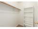 Walk-in closet featuring a wooden hanging rod and built-in white shelving for optimal storage and organization at 8450 S Stephanie Ln, Tempe, AZ 85284