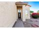 Front entrance featuring a decorative dark wood door, covered porch, and desert landscaping at 8450 S Stephanie Ln, Tempe, AZ 85284