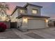 Two-story home with tan stucco, a two car garage and long driveway, at dusk at 8450 S Stephanie Ln, Tempe, AZ 85284