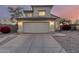 Two-story home with tan stucco, a two car garage and a driveway under an colorful evening sky at 8450 S Stephanie Ln, Tempe, AZ 85284