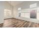 Sun-filled living room featuring high ceilings, wood-look floors, and large windows with plantation shutters at 8450 S Stephanie Ln, Tempe, AZ 85284