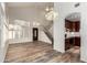 Spacious living room with wood-look floors, a chandelier, and an open view of the staircase and kitchen at 8450 S Stephanie Ln, Tempe, AZ 85284