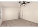 An unfurnished bedroom featuring a ceiling fan, neutral walls, carpet, and view into the bathroom at 8500 E Southern Ave # 550, Mesa, AZ 85209