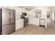 Open kitchen features white cabinets, stainless steel appliances, and plank flooring at 8500 E Southern Ave # 550, Mesa, AZ 85209