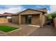 Home's backyard featuring gravel, a covered patio, and a small patch of artificial grass at 9222 W Roma Ave, Phoenix, AZ 85037