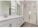 Bright bathroom features double sinks, white cabinets, and a walk-in glass enclosed shower at 9222 W Roma Ave, Phoenix, AZ 85037