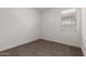Neutral bedroom features carpet flooring, a window with blinds, and fresh paint at 9222 W Roma Ave, Phoenix, AZ 85037