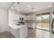 Bright kitchen with white cabinets, stainless steel appliances, quartz countertops, and sliding glass doors to backyard at 9222 W Roma Ave, Phoenix, AZ 85037