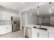 Open concept kitchen showcasing stainless steel appliances, white cabinets, a breakfast bar, and backyard views at 9222 W Roma Ave, Phoenix, AZ 85037