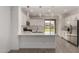 Bright kitchen features white cabinetry, stainless steel appliances, stylish pendant lighting and a view to the backyard at 9222 W Roma Ave, Phoenix, AZ 85037