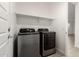 Laundry room features new appliances, tile floors, and a shelf for storage at 9222 W Roma Ave, Phoenix, AZ 85037