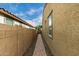 The side yard shows a pathway, offering a view of the sky with a beige wall at 9222 W Roma Ave, Phoenix, AZ 85037