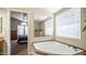 Relaxing bathroom featuring a large soaking tub and a view into the Primary bedroom at 9431 E Coralbell Ave # 6, Mesa, AZ 85208