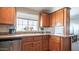 Well-lit kitchen boasts wood cabinetry, tiled countertops, a stainless steel dishwasher, and a large window at 9431 E Coralbell Ave # 6, Mesa, AZ 85208