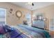 Bright bedroom with large windows, ceiling fan, and decorative accents at 9948 W Chipman Rd, Tolleson, AZ 85353