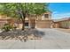 Inviting two-story home featuring a two-car garage, desert landscaping and mature shade tree in the front yard at 9948 W Chipman Rd, Tolleson, AZ 85353