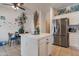 Modern kitchen featuring stainless steel refrigerator, white cabinets, and an island with seating at 9948 W Chipman Rd, Tolleson, AZ 85353