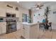 Bright kitchen with white cabinets, stainless steel appliances, and a center island with a white countertop at 9948 W Chipman Rd, Tolleson, AZ 85353