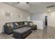 Spacious living room featuring gray sectional sofa, plush ottoman, and wood-look flooring at 9948 W Chipman Rd, Tolleson, AZ 85353