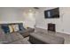 Relaxing living room with comfy grey sofa and ottoman, TV and fireplace at 9948 W Chipman Rd, Tolleson, AZ 85353