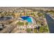 Aerial view of community pool with lap lanes and a splash pad, plus clubhouse, surrounded by lush palm trees at 1008 W Heatherwood St, San Tan Valley, AZ 85140