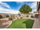 Artificial grass in backyard with desert landscaping and decorative fountain at 1008 W Heatherwood St, San Tan Valley, AZ 85140